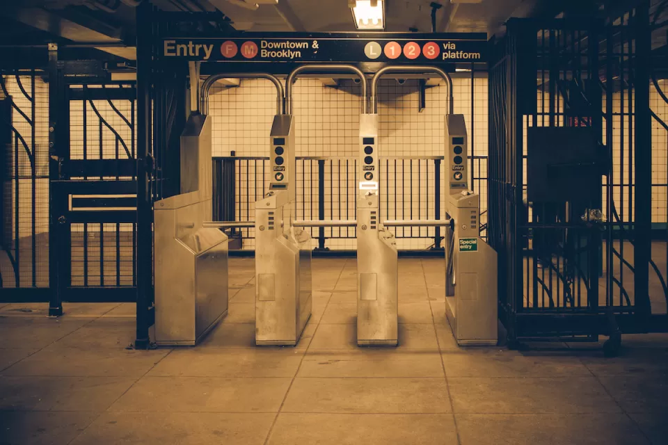 Sepia-toned photo of New York City subway turnstiles.